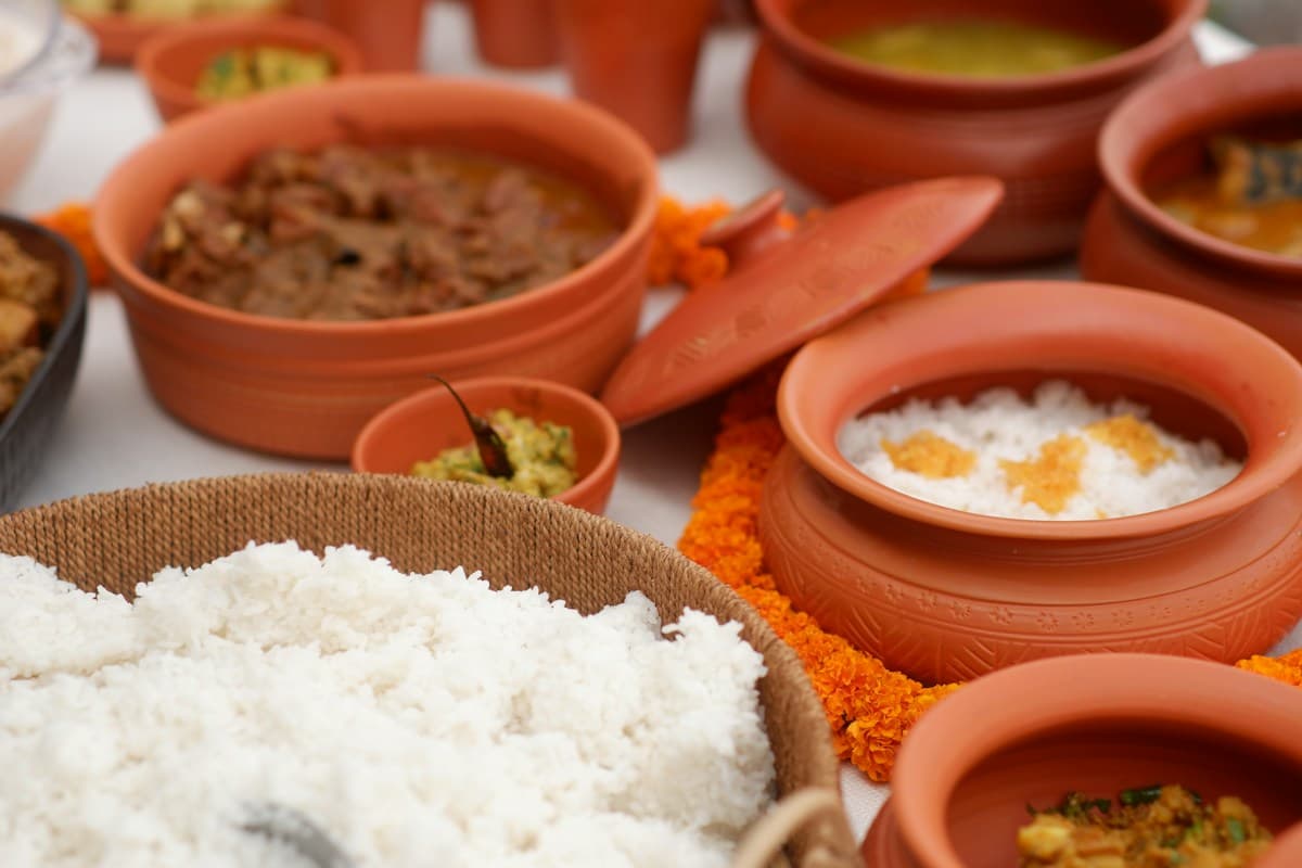 Rice and curries served in clay pots on a table