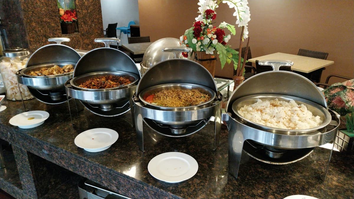 Covered serving dishes set out on a buffet counter